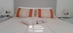 - un lit avec des serviettes et des oreillers dans l'établissement Apartamento Calderón, Feel Cádiz, à Cadix