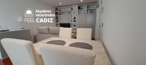 une salle à manger avec une table et des chaises blanches dans l'établissement Apartamento Calderón, Feel Cádiz, à Cadix