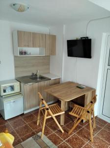 een keuken met een houten tafel en 2 stoelen bij Guesthouse Kolevi in Lozenets