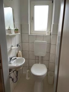 een badkamer met een toilet, een wastafel en een raam bij Ferienwohnung Hinterberg in Fürstenstein