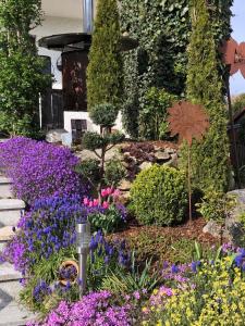 a garden with purple and purple flowers in front of a house at Ferienwohnung Hinterberg in Fürstenstein