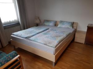 een kleine slaapkamer met een bed met blauwe lakens bij Ferienwohnung Hinterberg in Fürstenstein