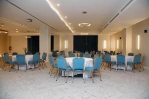 une chambre avec des tables et des chaises bleues et une chambre avec dans l'établissement Golden Tulip Opera Alger, à Ouled Fayet