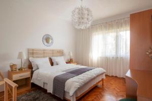 - une chambre avec un grand lit et un lustre dans l'établissement Seafront Apartment Jadri, à Umag