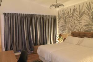 a bedroom with a bed and a window with curtains at CASAS DA FORTALEZA Casa da Solaina in Outeiro de Rei