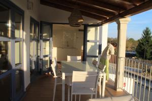 a porch with a table and chairs on a balcony at CASAS DA FORTALEZA Casa da Solaina in Outeiro de Rei