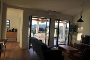 a living room with a couch and chairs and sliding glass doors at CASAS DA FORTALEZA Casa da Solaina in Outeiro de Rei +6 photos
