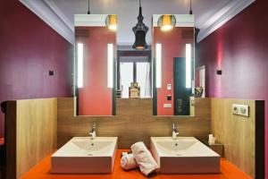 パリにあるLe Paris Singulierのバスルーム(シンク2台、大きな鏡付)