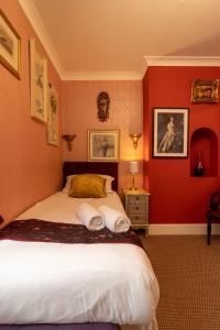 ブラックプールにあるHotel Rougeの赤い壁のベッドルーム1室(大型ベッド1台付)