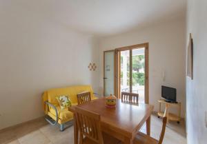 sala de estar con mesa y sofá amarillo en Blue Area Apartments - FromHomeToSalento, en Torre dell'Orso