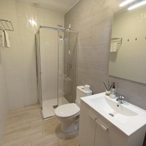 a bathroom with a shower and a toilet and a sink at AlbergueMyway in Astorga
