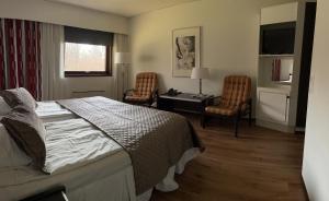 a bedroom with a bed and two chairs and a desk at Eckerö Hotell & Restaurang in Eckerö +86 photos