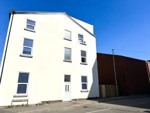 a white building with a bench in front of it at Regent Docks-Free Parking in Liverpool