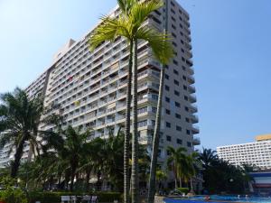 een hoog gebouw met palmbomen ervoor bij View Talay 2 A in Jomtien Beach