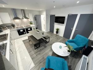 a kitchen and living room with blue chairs and a table at Regent Docks-Free Parking in Liverpool