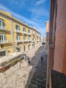 um grupo de pessoas andando por uma rua com edifícios em Matera Like Home - rooms - Via del Corso em Matera