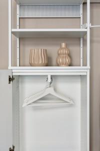 a closet with white shelves and a white door at Hotel 1A Apartment Berlin in Berlin