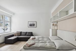 een witte woonkamer met een bed en een bank bij Arbio I 1A Rooms & Apartments Prenzlauerberg Berlin in Berlijn