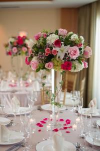 a table with a vase filled with pink and white flowers at Edgewater Beach Hotel in Naples +38 photos