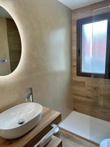 bagno con lavandino e specchio di Hotel Arco San Vicente ad Ávila