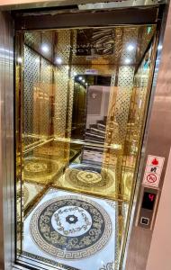a gold elevator with a clock in a room at Crowned Hotel in Istanbul