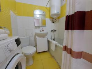 La salle de bains est pourvue de toilettes, d'un lavabo et d'un lave-linge. dans l'établissement Апартаменти Молоді LutskDoba, à Loutsk