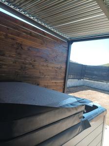 a bed in a room with a wooden wall at Loft sauna jacuzzi ospariegeois in Lavelanet