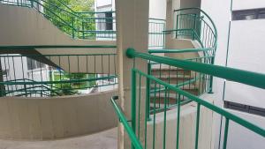 a spiral staircase in a building with green railings at Apartamento Aconchegante e Confortável com ou sem Ar Condicionado in Porto Alegre