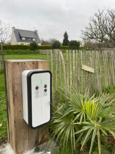 a soap dispenser is attached to a wooden fence at Appartement et Studio Gîtes de L'Odet in Clohars-Fouesnant