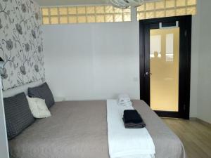 Schlafzimmer mit einem großen Bett und einer schwarzen Tür in der Unterkunft Comfort StudioCity with balcony in Kamjanez-Podilskyj