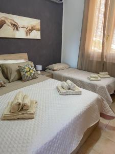 a room with two beds with towels on them at L'Oasi dell'Eremita in Mondello