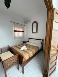 Schlafzimmer mit einem Bett, einem Fenster und einem Spiegel in der Unterkunft Riad NEJJARINE in Marrakesch