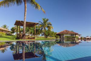 a pool at a resort with a palm tree at Pousada Outeiro in Praia do Espelho