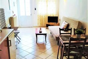 a living room with a couch and a table at Cozy Maisonette in Moúdhros +11 photos