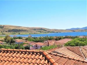 a view of a town with a lake and roofs at Cozy Maisonette in Moúdhros