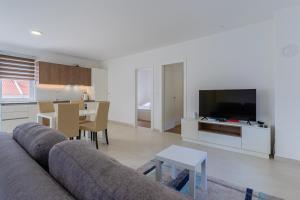 a living room with a couch and a tv and a table at BLUE SKY in Cres