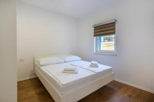 a white bed in a room with a window at BLUE SKY in Cres