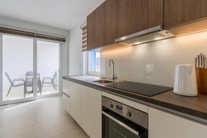 a kitchen with a sink and a view of a patio at BLUE SKY in Cres