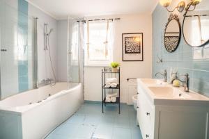 a bathroom with a tub and a sink and a bath tub at Alpine apartments Marcella in Žirovnica