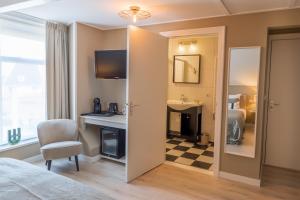 Schlafzimmer mit einem Bett, einem Schreibtisch und einem Spiegel in der Unterkunft Hotel Restaurant Toxopeus in Anjum