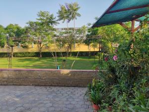瓦拉納西的住宿－Brick Field，享有带围栏和树木的花园美景。