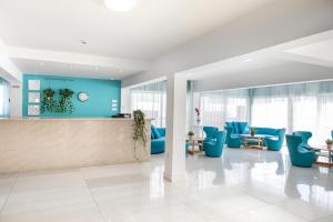 un vestíbulo de oficina con sillas azules y un mostrador en Mia Hotel Apartment, en Ayia Napa