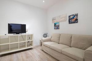 een woonkamer met een bank en een flatscreen-tv bij Two bedroom flat in PobleNou in Barcelona