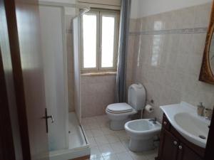La salle de bains est pourvue de toilettes, d'un lavabo et d'une fenêtre. dans l'établissement Santi Palace Hotel, à Gravina di Catania