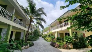 un chemin entre deux bâtiments plantés de palmiers dans l'établissement Arkbar Beach Club, à Chaweng