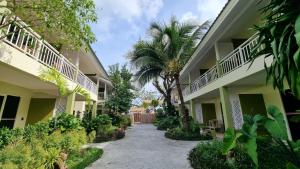 a walkway between two buildings with palm trees at Arkbar Beach Club & Resort in Chaweng