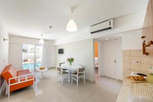 een keuken en een woonkamer met een tafel en stoelen bij Mia Hotel Apartment in Ayia Napa
