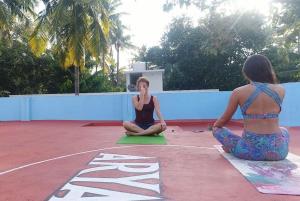 Dos mujeres sentadas en una clase de yoga en una cancha en Aryavilla Heritage, en Varkala