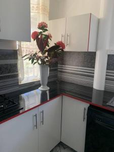 a kitchen with a vase with flowers on a counter at Modern with class near Airport in Nadi