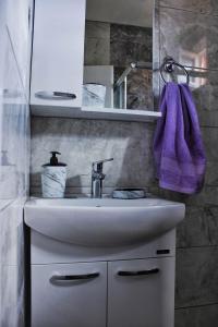 a bathroom with a sink and a purple towel at My place studio in Ohrid